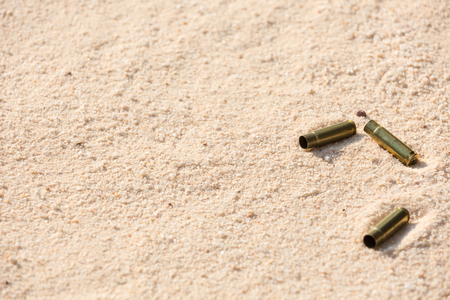 Brass casing on the beach sand in morning lightの写真素材