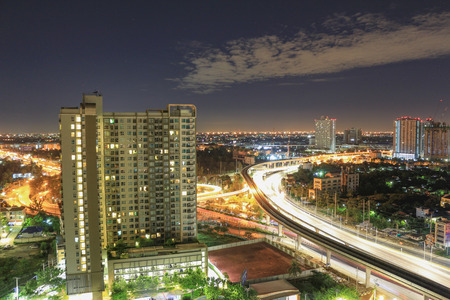 Apartment windows at night near the modern highway system with heavy traffic. The business district is far away from this residential district mostly full of high rise condos.の写真素材