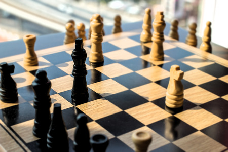Chess battle with high contrast and lighting, looking outside window in the background.  Copy space.の写真素材