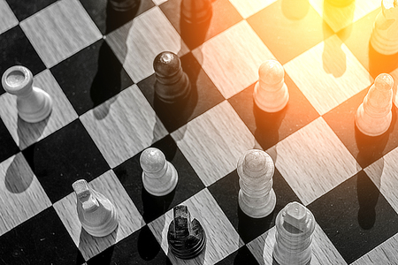 A glimmer of hope and warm sun in the corner of this chess battle for business concept where clever...