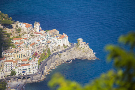 Almafi coast city on the cliffsin Italy for popular tourist destination with winding road near the blue ocean and tree out of focus.の写真素材