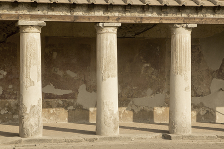 Pompeii pillars in of stone in ancient city for Italian European travel vacation destination.  Long evening shadows.の写真素材