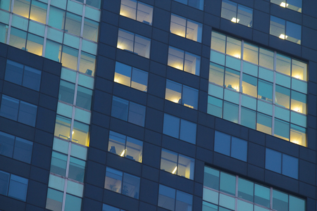 City apartment windows at night with lights for privacy concept.の写真素材