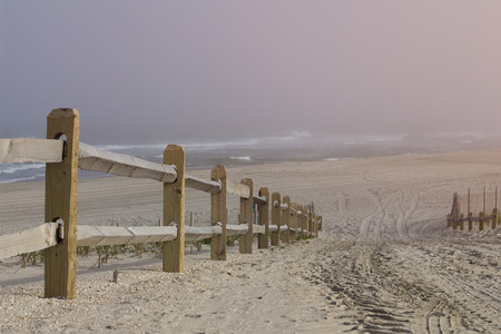 Wooden railing leading to the shore and swimming in epic and conceptual hilltop perspective.  Copy space for words.の写真素材