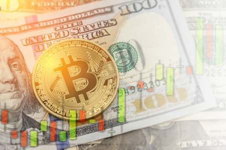 Bitcoin and dollar.  BTC market symbol cryptocurrency rising above the united states dollar.  Gold metal bitcoin on top of paper currency.  Copy space for text and wording.の写真素材
