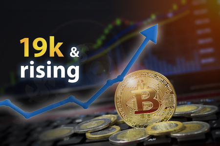 Bitcoin currency rising arrow price record highs on keyboard computer with golden bitcoin and other currencies.の写真素材