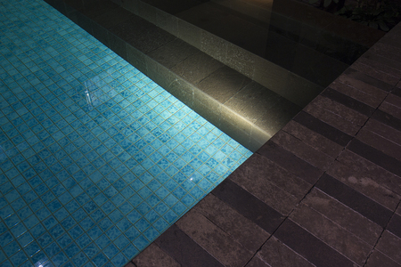 Romantic evening mood lighting casting shadows onto a romantic setting near the pool.  This luxury home has some of the best landscaped gardens and tropical flora in the world.の写真素材