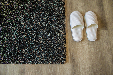 Cozy warm slippers on plush carpet for comfort and warmth in modern living room.の写真素材