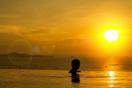 Sunset for freedom concept with woman in the water and beautiful silhouette.  Totally free and living a healthy life.の写真素材