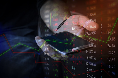 Financial investor with mobile device for business and connected to the market instantly around the...
