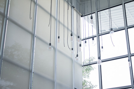 Blurred interior design with bright white lighting and hanging lights in cafe or restaurant.