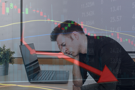 Depressed man as stock portfolio plummets and money is lost.の写真素材
