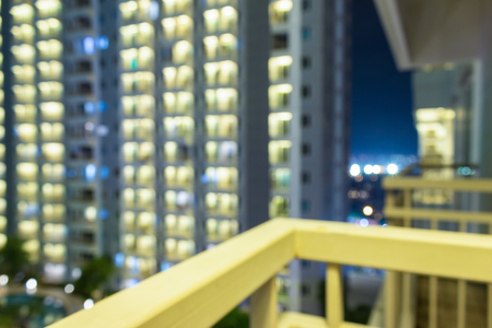 Bokeh apartment windows at night for blurry modern highrise city scene.の写真素材