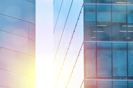 White copy space flare over modern building facade in glass and metal.  New construction highrise buildings for business and finance.の写真素材