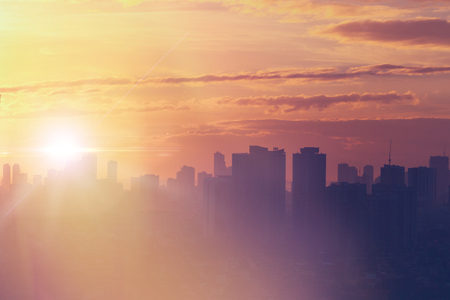 Sunset view of city skyline with bright emotional and powerful energy from light.  First sunlight at dusk.の写真素材