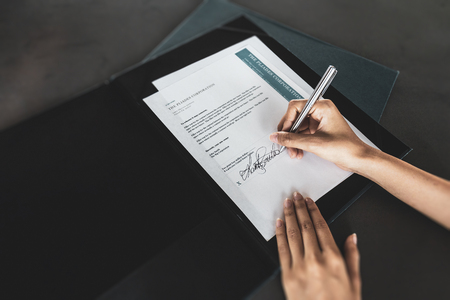 Financial business contract.  Reading paperwork details and signing business contract.