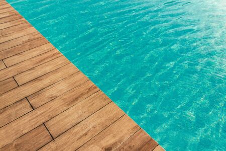 Pool with wood open copyspace area.  Beautiful clean swimming pool with bright blue water.  Luxury relaxation and lifestyle travel concept.の写真素材