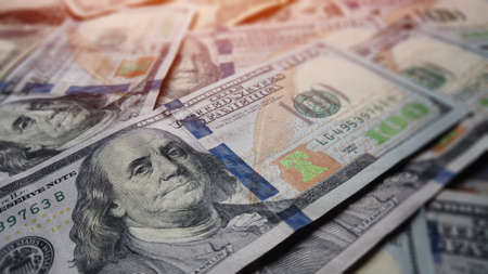Hundred dollar benjamin franklin billls in pile for business and financial concept.  American US dollar federal reserve background texture.  Cash and prosperity for economic impact and financial abundance.の写真素材