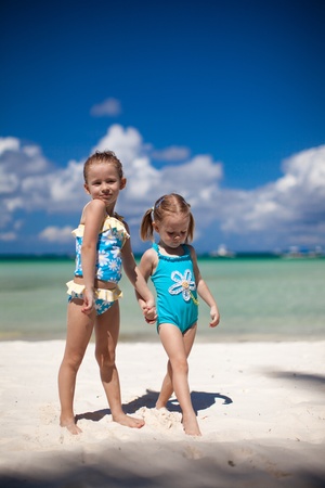 two little sisters at tropical beachの写真素材