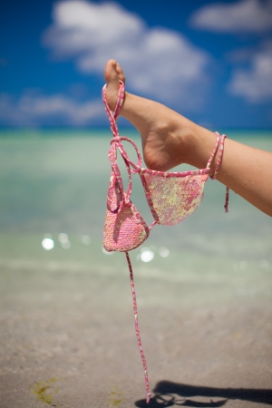 Woman leg hold pink bra isolated on exotic backgroundの写真素材