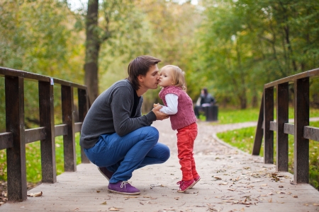 Father kissing his little daughter in a parkの写真素材