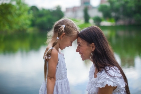 Young beautiful mother and her daughter having fun outdoorsの写真素材