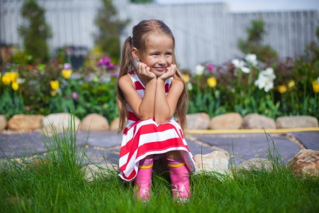 Beautiful girl sitting in her garden and laughtingの写真素材