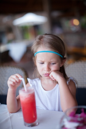Adorable little girl having breakfast at resort restaurantの写真素材