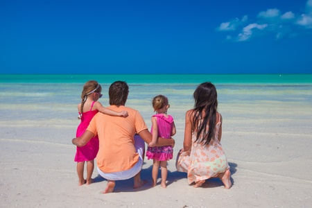 Rear view of young family with two kids on caribbean beach vacationの写真素材