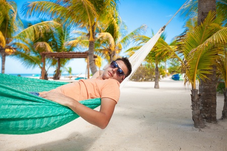 Young man in hammock on the exotic tropical resortの写真素材