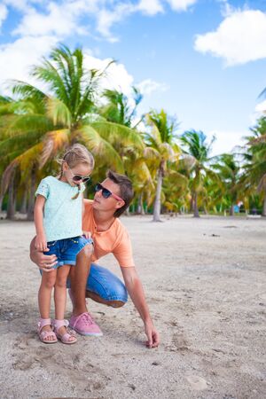 Young father and his little daughter on exotic white sand beachの写真素材