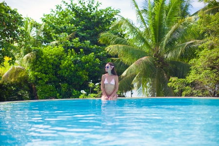 Beautiful young woman enjoying the luxury quiet swimmingpoolの写真素材