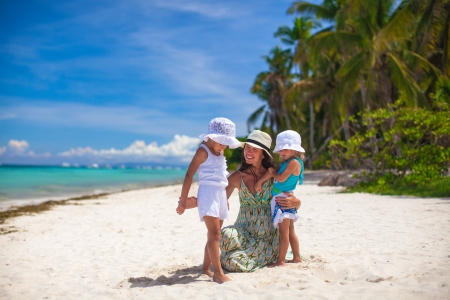 Young mother and two her fashion kids at exotic beach on sunny dayの写真素材
