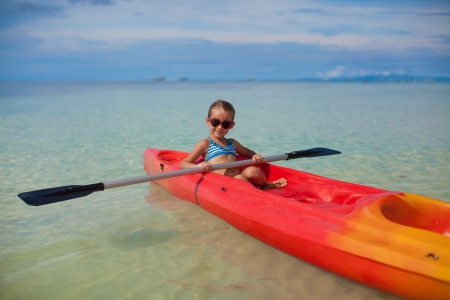 brave little cute girl floating in a kayak on the high seasの写真素材