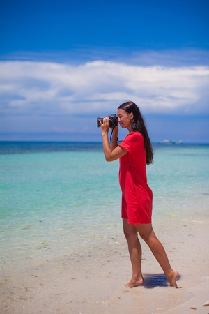 profile of young beautiful woman photographed beautiful seascape on white sand beachの写真素材
