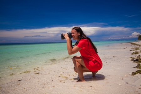 profile of young beautiful woman iphotographed beautiful seascape on white sand beachの写真素材