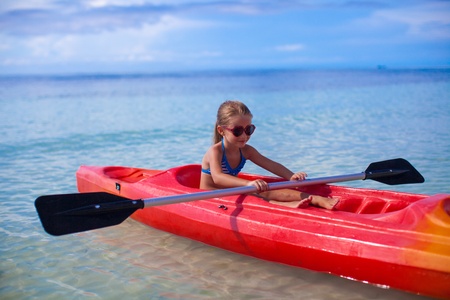 Little adorable girl kayaking in the clear seaの写真素材