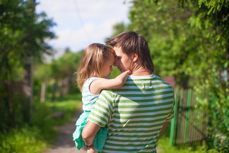A young father with a daughter in the village outdoorsの写真素材