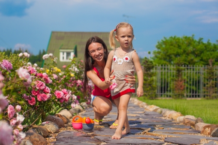 Young mother with her cute daughter have fun in the gardenの写真素材
