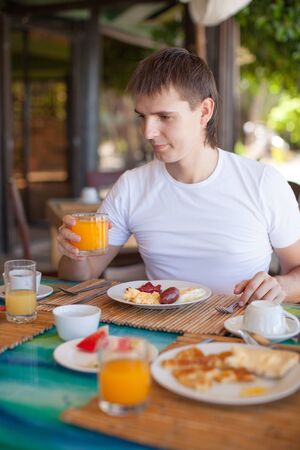 Young man having breakfast at resort restaurantの写真素材