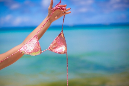 Woman hand holding pink bra isolated on exotic backgroundの写真素材
