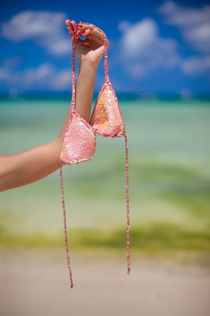 Woman's hand holding pink bra background the seaの写真素材