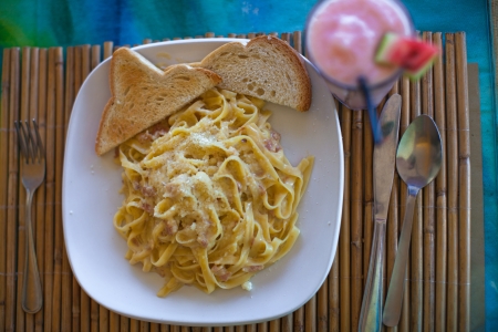 plate of pasta on a table in outdoor restaurantの写真素材