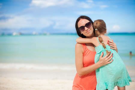 Young beautiful mother and her adorable little daughter at tropical beachの写真素材