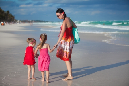 Young mother and two her fashion kids at exotic beach on sunny dayの写真素材