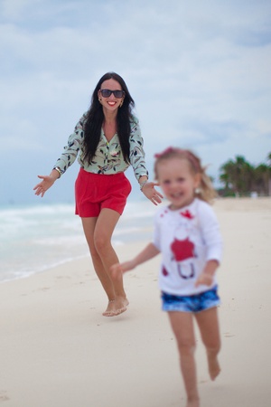 Young mother and her cute happy daughters enjoy summer vacationの写真素材