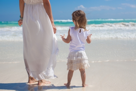 Back view of mother and his little daughter looking on the sea at tropical beachの写真素材