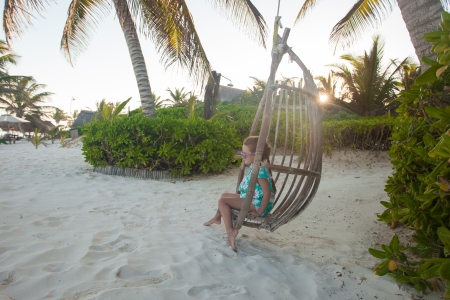 Happy little girl enjoy swing on white sandy Caribbean beachの写真素材