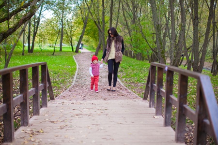 Young mother walking with her little daughter in autumn parkの写真素材