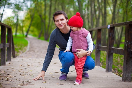 Portrait of Young father walking with his little cute daughter in autumn parkの写真素材